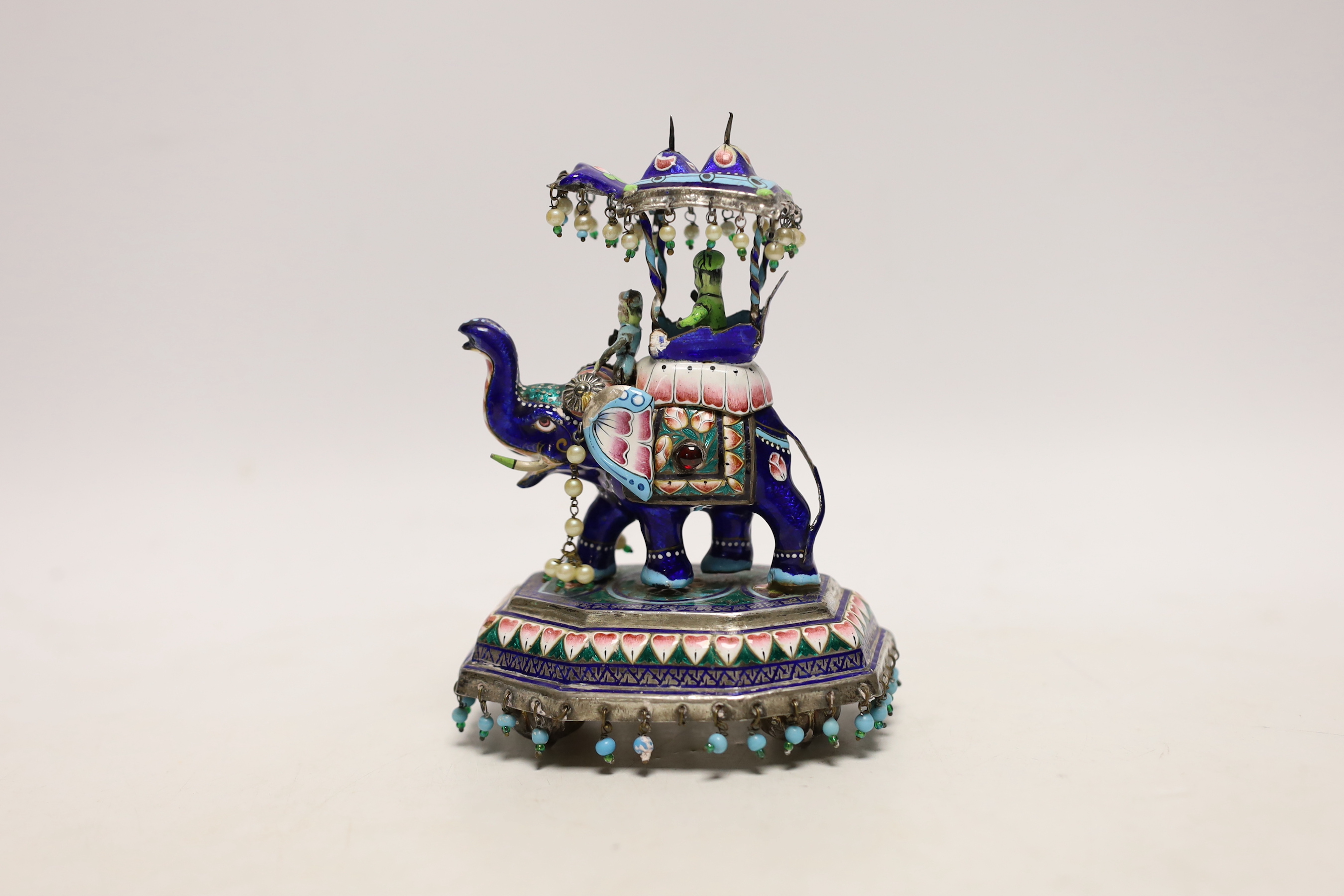 An Indian? white metal, polychrome enamel and gem set model of an elephant with Howdah, on octagonal base, length 96mm.